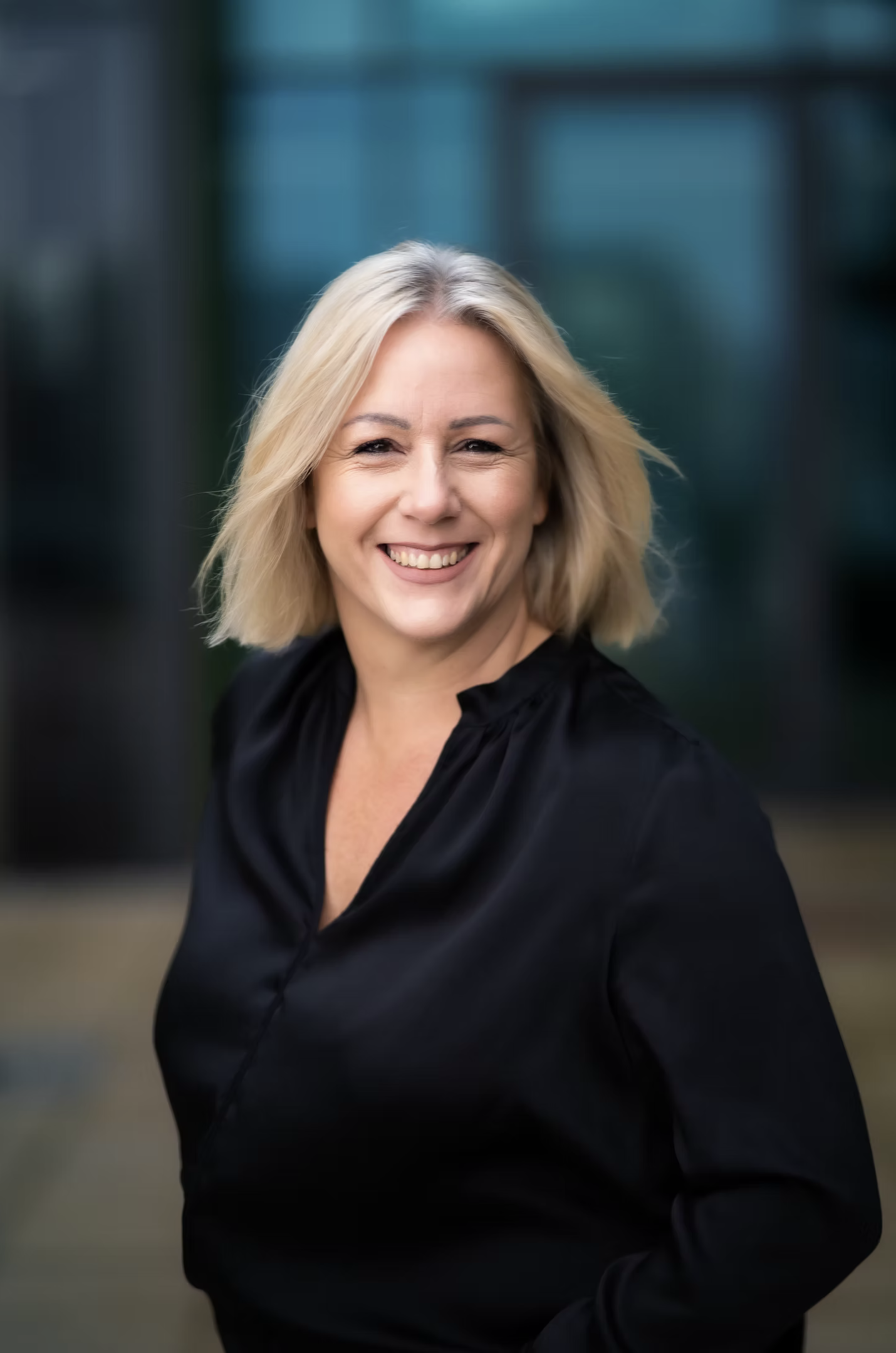 Businessportrait einer blonden Frau vor modernem Gebäude, Fotoproduktion TMC Media, Burgau