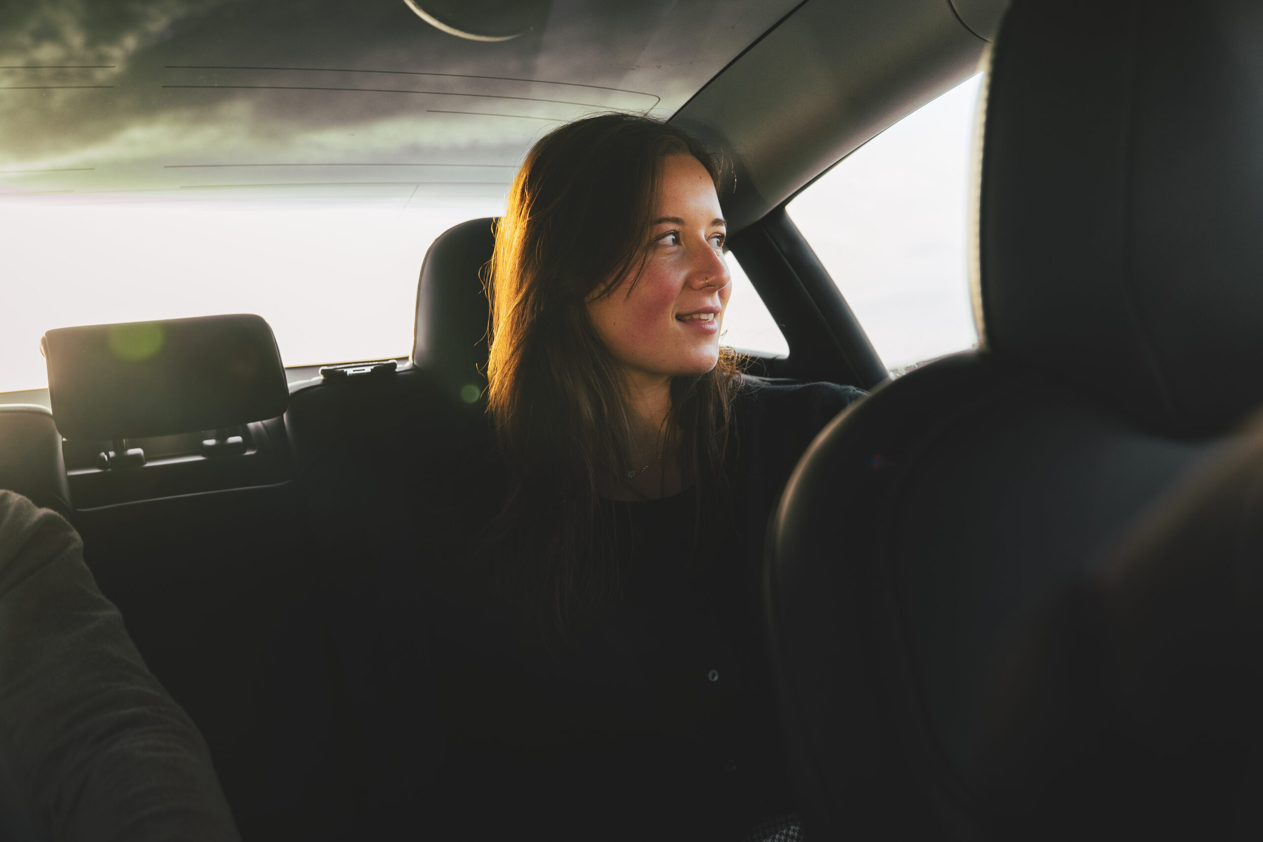 Automobil Lifestylefotografie: Junge Frau im Tesla Model 3 am Strand in Irland, Fotoproduktion von TMC Media